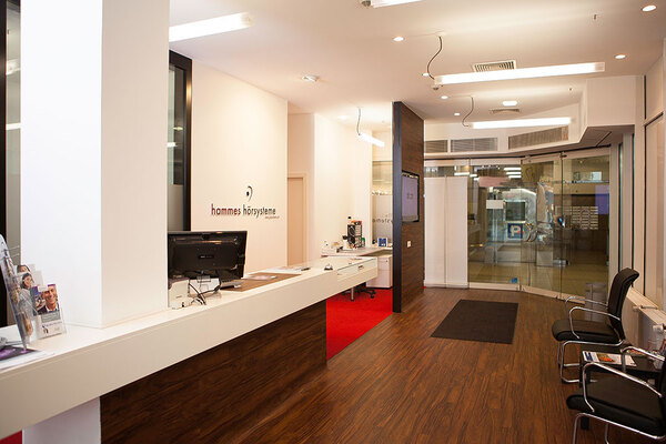 Modernes Hörgeräteakustiker-Geschäft mit Empfangstresen, Wartebereich und Glastür.